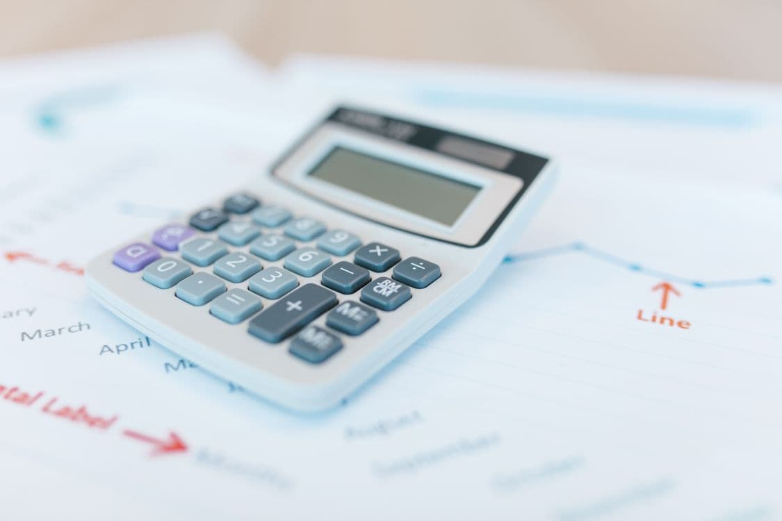 Calculator on financial documents, illustrating gross and net gaming revenue calculations